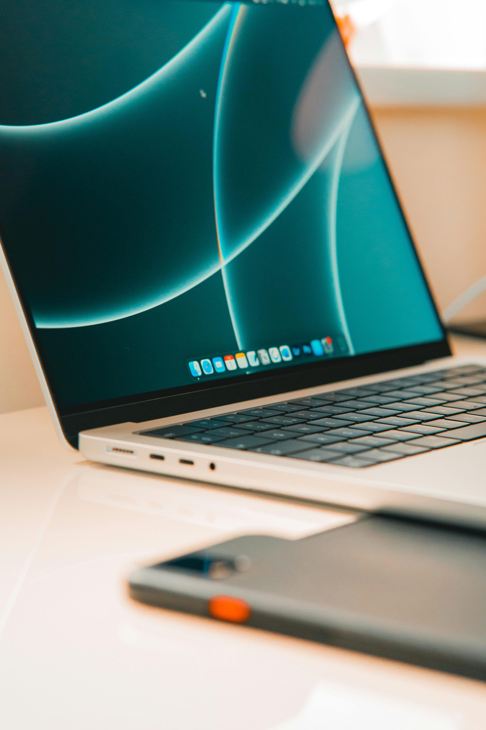 A close-up of a sleek laptop and smartphone on a desk, showcasing modern technology.