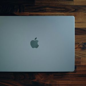 Sleek MacBook closed on a rich wooden surface, highlighting its minimalist design and modern technology.